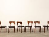 a set of six dining chairs with black leather upholstered seats