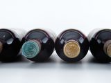 bottles of wine are lined up in a row on a white surface