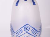un vase bleu et blanc posé sur une surface blanche