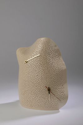 un vase blanc orné d'une horloge, posé sur une table