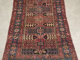an antique persian rug with a red and blue design