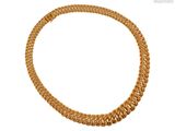 gros plan d'un collier en or sur fond blanc