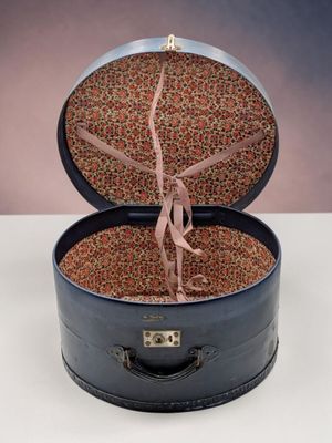 une valise ouverte contenant une cravate, posée sur une table