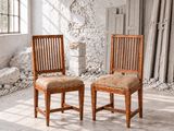 une paire de chaises en bois dans une pièce abandonnée dotée d'une fenêtre