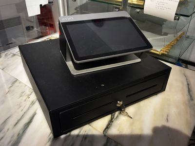une tablette posée sur une caisse enregistreuse