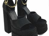 un gros plan sur une paire de sandales noires à talons hauts