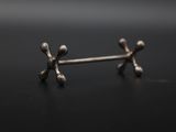 a close up of a pair of silver earrings on a black surface