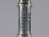 a silver vase that has writing on the side of it