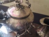 a silver tea pot sitting on top of a wooden table
