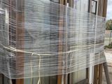a lot of plastic wrapped windows on a pallet