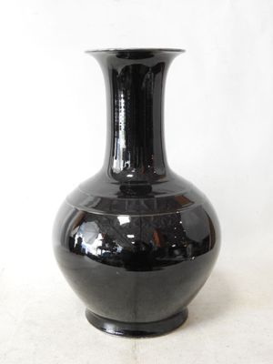 a black vase that is sitting on a table