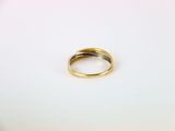 a close up of a gold wedding ring on a white surface
