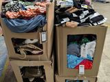 deux cartons sur lesquels sont posés des vêtements, dans un entrepôt