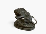 bronze statue of a lion on a rock with a mouse in its mouth