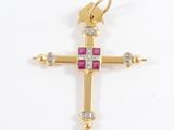 a close up of a gold cross with pink stones on a white background