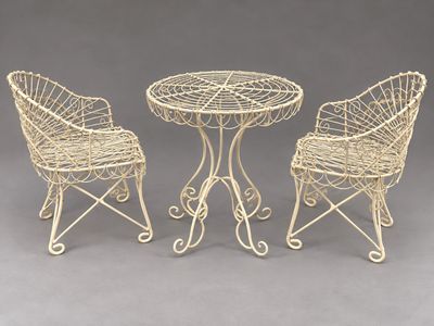 a set of three wrought iron chairs and a table