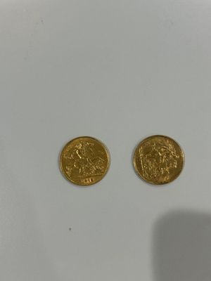 a pair of gold coins sitting on top of a white surface