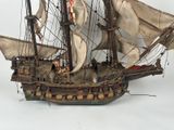 a model of a ship on display on a white surface