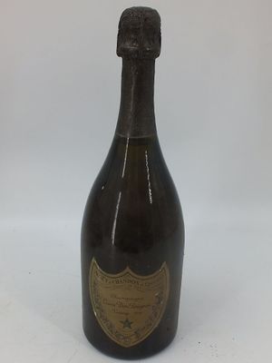 une vieille bouteille de champagne posée sur une table blanche