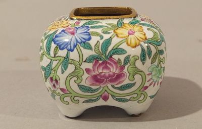 a white vase with colorful flowers on it sitting on a table