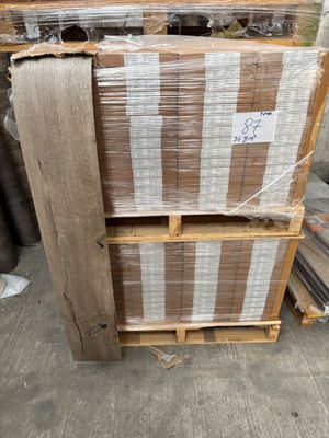 plusieurs palettes de bois sont empilées sur des palettes dans un entrepôt