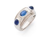 un gros plan d'une bague ornée de pierres bleues sur fond blanc