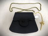 an image of a black purse with a gold chain and a key