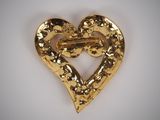 a close up of a heart shaped brooch with a key in it