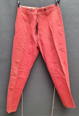 un pantalon rouge suspendu à une corde à linge