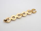 a close up of a gold chain bracelet on a white surface