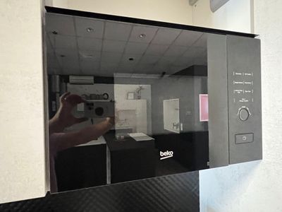 une personne en train de prendre une photo de l'intérieur d'un micro-ondes