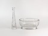 un vase en verre et un bol en verre posés l'un à côté de l'autre