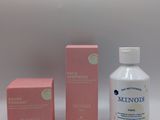 two bottles of hand sanitizer and a box of soap on a white surface