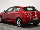 the rear end of a red car parked in a room