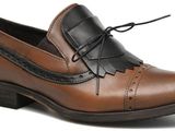 les chaussures marron et noires sont posées sur une surface blanche