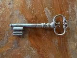 a silver key sitting on top of a wooden table