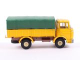 a yellow truck with a green cover on the back