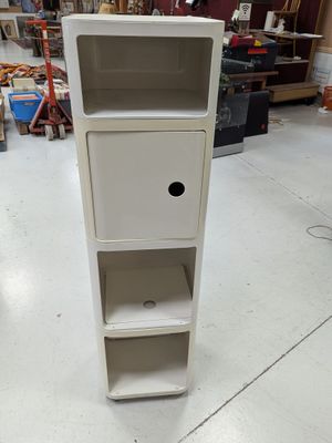 a tall white cabinet with two shelves in the middle of the room