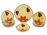 a set of four plates and a bowl on a white surface