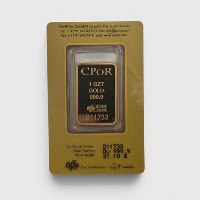 un gros plan d'un lingot d'or dans un emballage posé sur une surface blanche