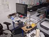 a desk with a computer, printer, and other items on it