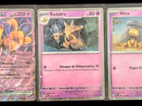 three pokemon cards are displayed on a table with a black background