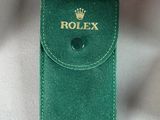 a green case that has a rolex logo on it
