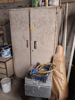 a refrigerator in a room with a lot of stuff on the floor