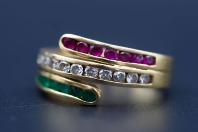 une photo en gros plan d'une bague en or sertie de diamants et d'émeraudes