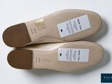 two pairs of beige shoes on a white surface with a white background