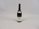 une bouteille de vin rouge posée sur une table blanche