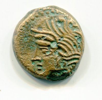 une vieille pièce de monnaie ornée d'un motif, posée sur une surface blanche