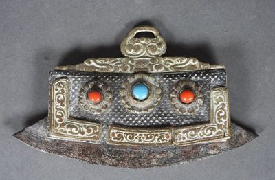 une vieille broche en argent et turquoise, ornée de pierres rouges et bleues