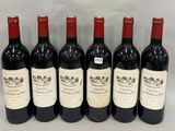 six bottles of red wine lined up in a row on a table